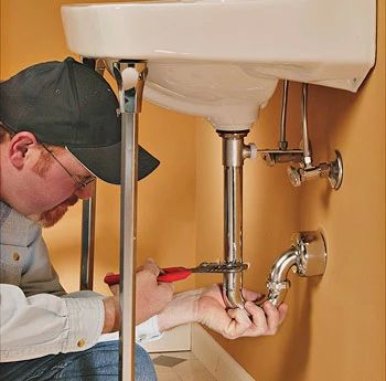 Plumber working on the kitchen pipes